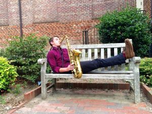 Student practicing saxophone outside Person Hall, 2016